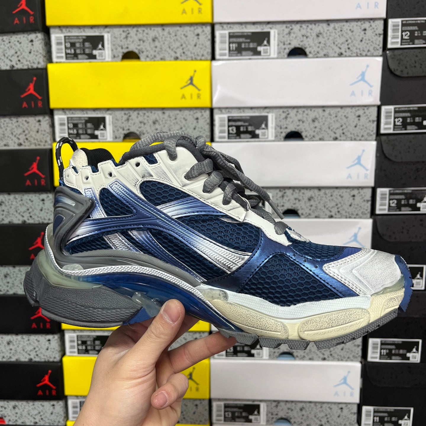 Blue and white running sneaker angled side view with gray laces