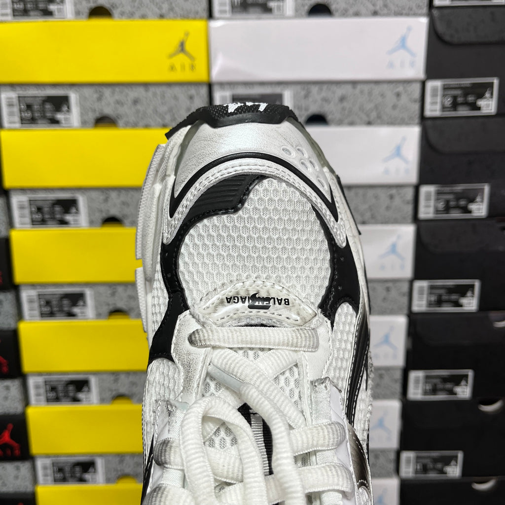 Balenciaga unisex sneaker heel view, white textured fabric with black trim and laces