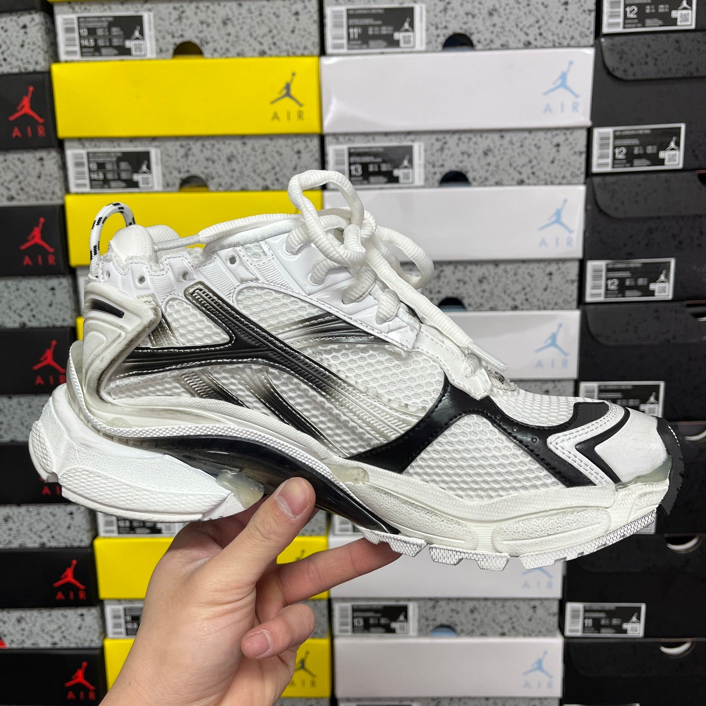 Balenciaga unisex sneaker front side view, white mesh with black stripe and silver overlays
