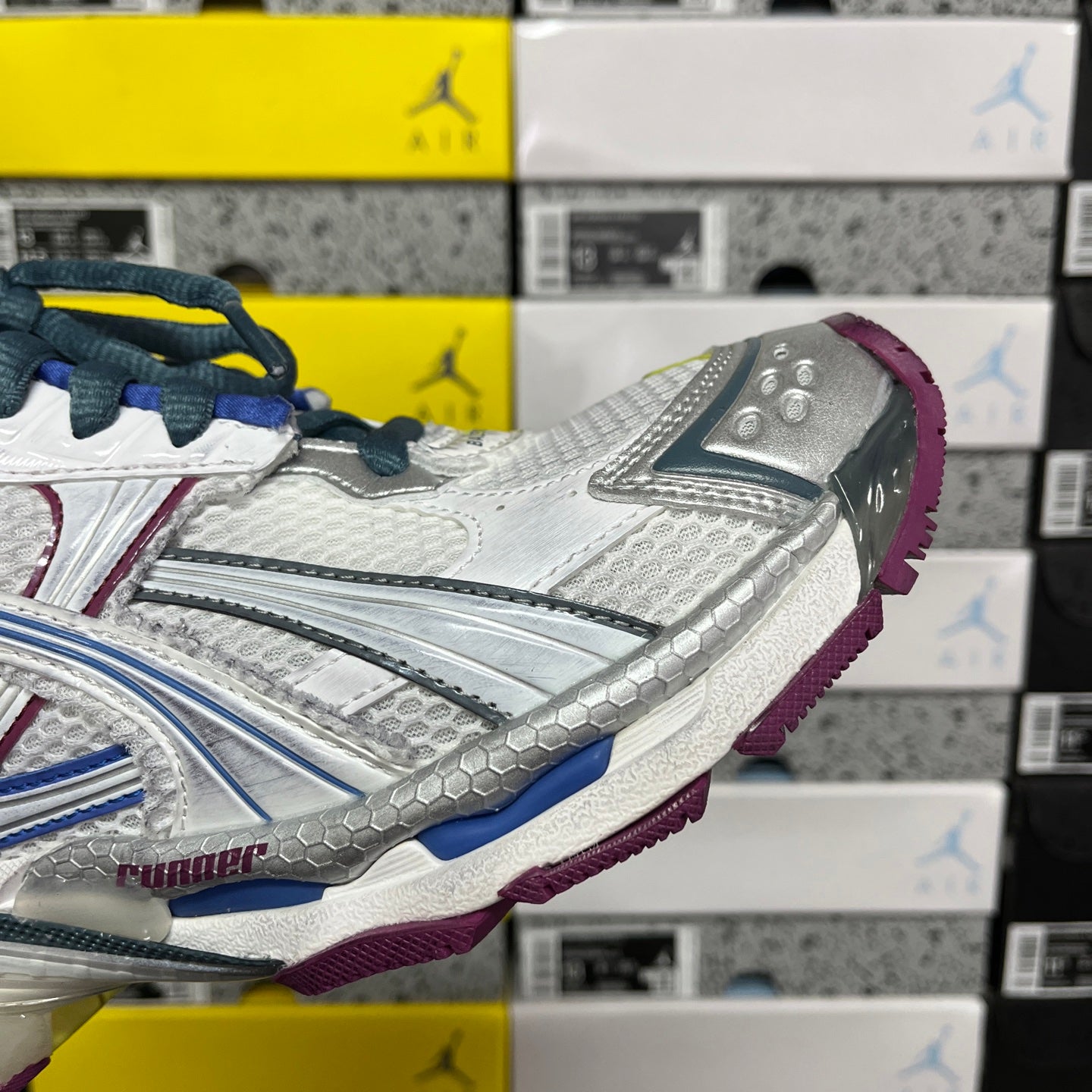 Balenciaga unisex running shoe side view, white upper with silver overlays and purple outsole