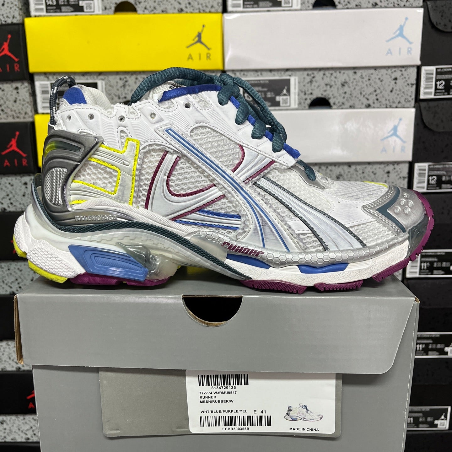 Balenciaga unisex running shoe on box, white upper with blue laces, silver panels, neon trim