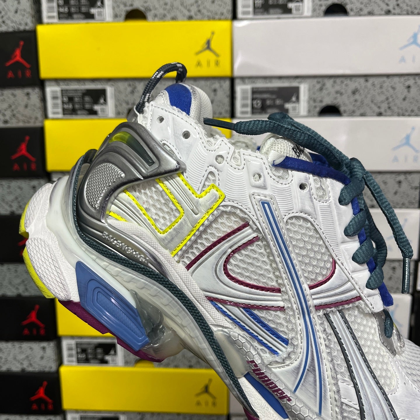 Balenciaga unisex running shoe front quarter view, white upper with blue laces and silver heel