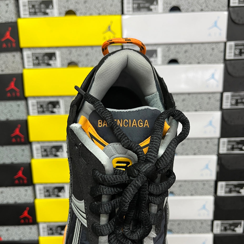 Balenciaga sneaker heel view with black knit upper, orange accents, Balenciaga text
