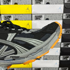 Balenciaga sneaker side view, black and gray upper with orange outsole trim