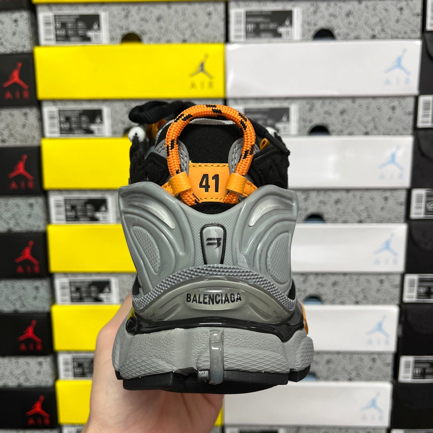 Balenciaga sneaker back view with orange heel tab and gray sole