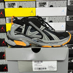 Balenciaga unisex sneaker with black upper, gray stripes, orange edge sole