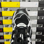 Runner sneaker tongue area, black mesh with white trim and black laces