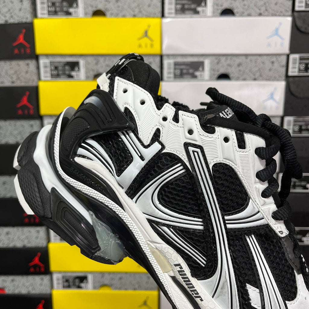 Runner sneaker, black and white quarter view with perforated panels and laces