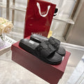 Black Gucci slide sandals with embossed GG pattern on the strap and footbed