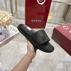 Black slide sandals with embossed GG logo pattern on the strap, side profile view