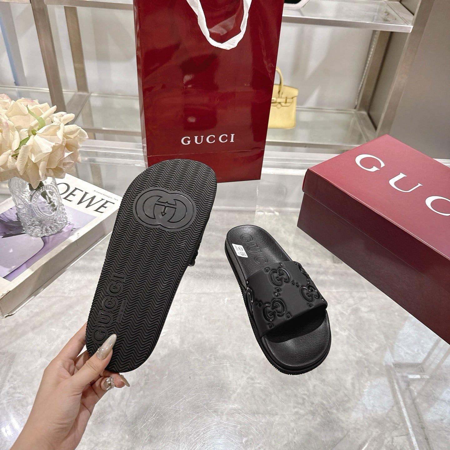 Black slide sandals showing textured outsole and embossed logo on the underside