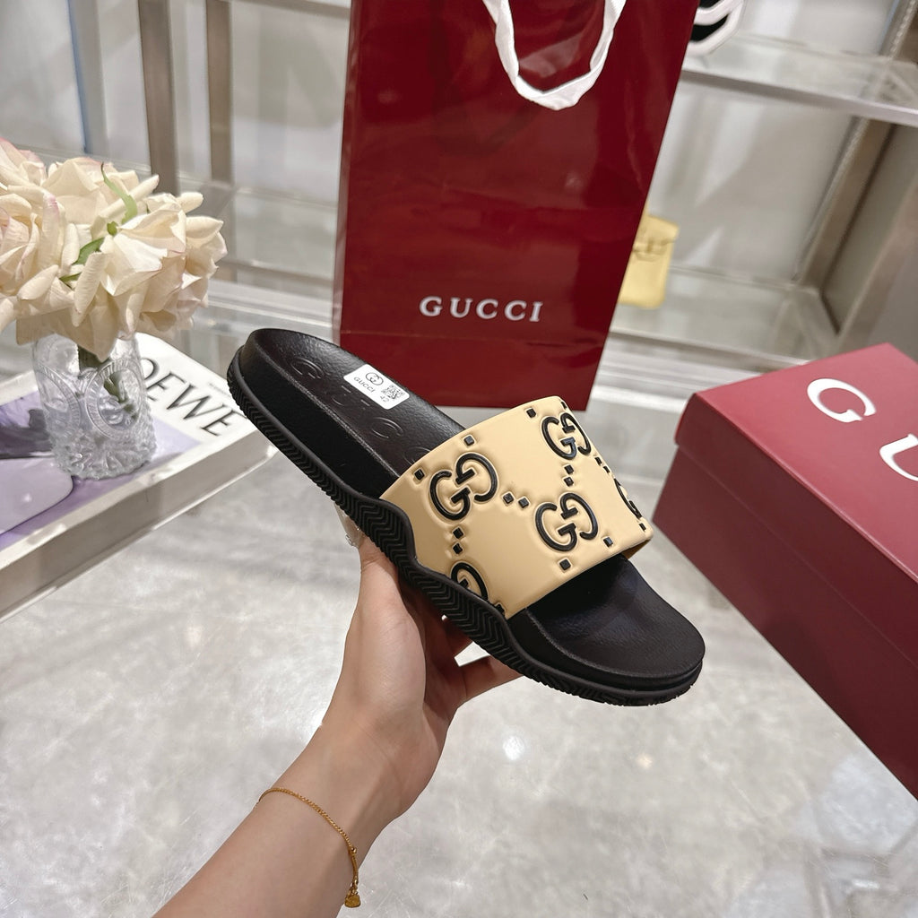 Black slide sandal with beige GG logo strap, side profile with ridged sole