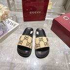 Pair of Gucci slide sandals, black sole with beige GG logo patterned straps