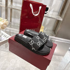 Gucci black slide sandals with GG monogram strap and textured footbed