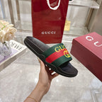 Gucci slide sandal showing black sole with textured pattern and GG web strap