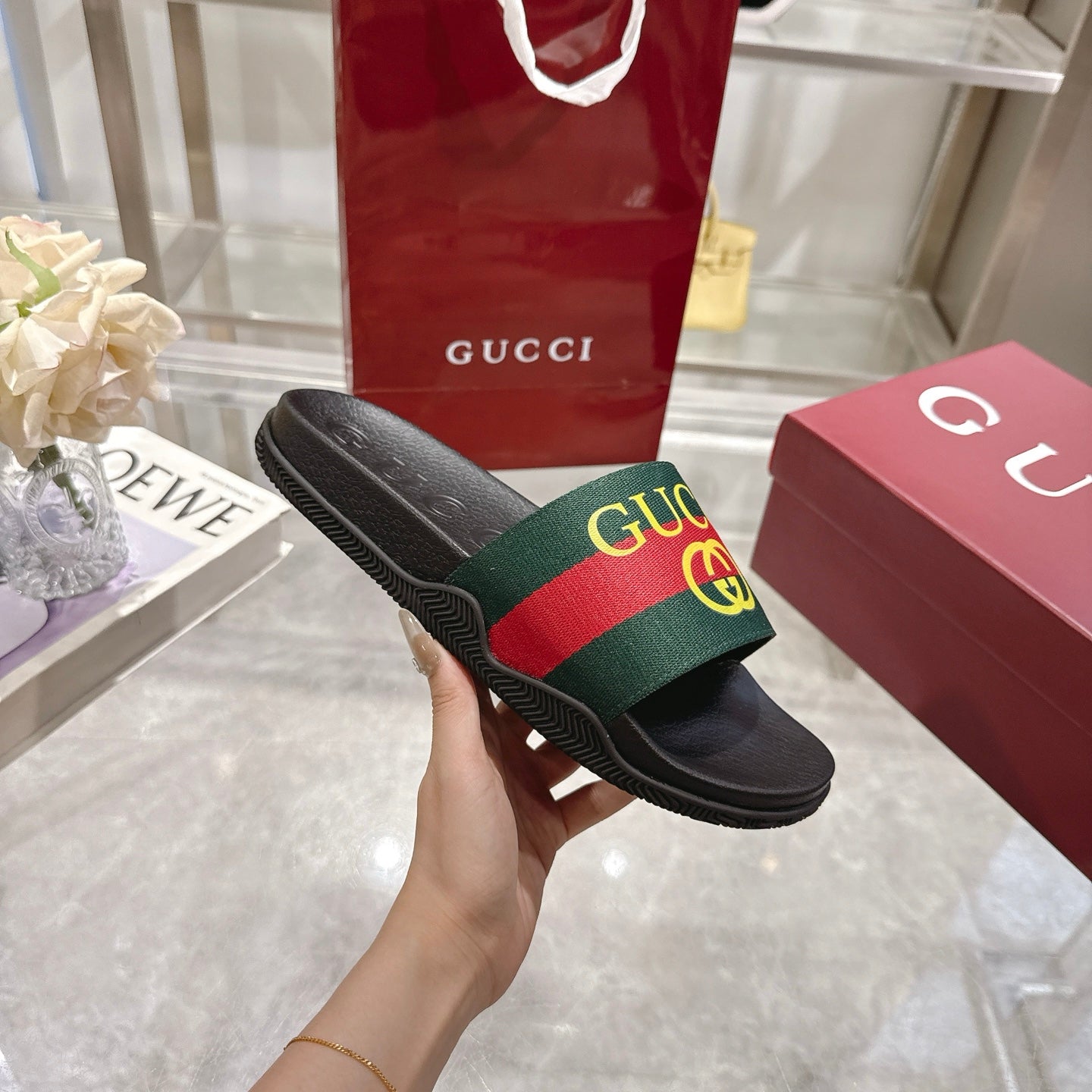 Gucci slide sandal showing black sole with textured pattern and GG web strap