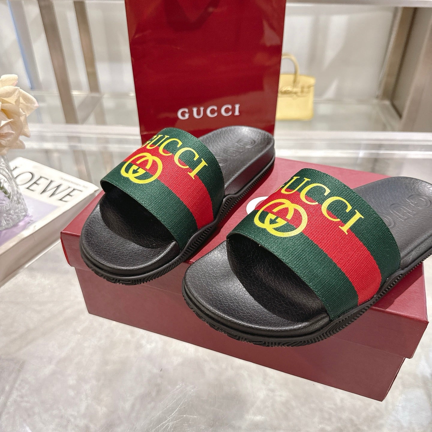 Gucci slide sandals featuring black sole and green-red-green GG print web band