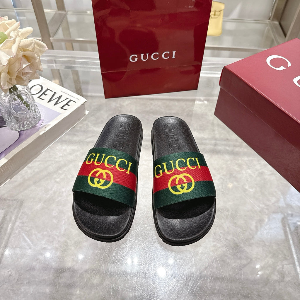 Gucci black slide sandals with green-red-green GG striped band on the upper