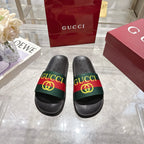 Gucci black slide sandals with green-red-green GG striped band on the upper