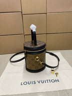 Louis Vuitton mini bucket bag with monogram canvas, black zipper top, and wrist strap