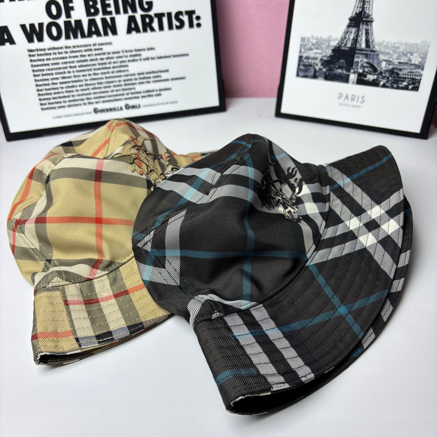 Two plaid bucket hats: one beige with multicolor checks, one black with blue checks
