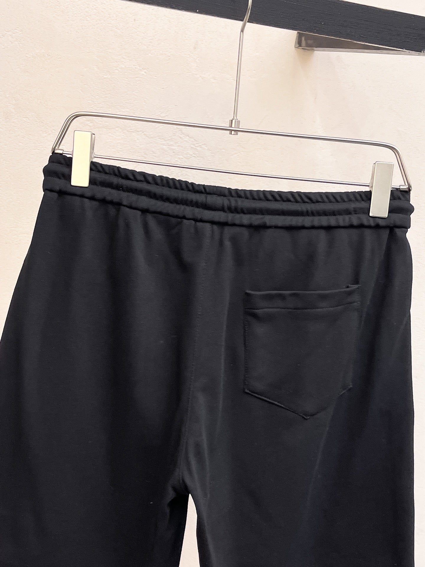 Black drawstring shorts with elastic waistband and front patch pocket