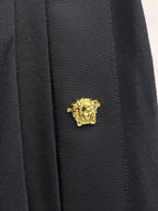 Gold crest emblem on black shorts side panel near pocket