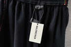 Black Balenciaga shorts with hanging Balenciaga tag at elastic waistband.