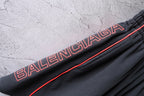 Black Balenciaga shorts with embroidered red logo text on side seam and contrast trim.