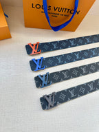 Louis Vuitton monogram belts in dark blue with orange LV buckles, laid out