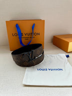 Louis Vuitton monogram belt with dark leather strap and metal V buckle, side view