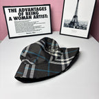 Side view of plaid bucket hat with embroidered crest; black, white, and blue checks