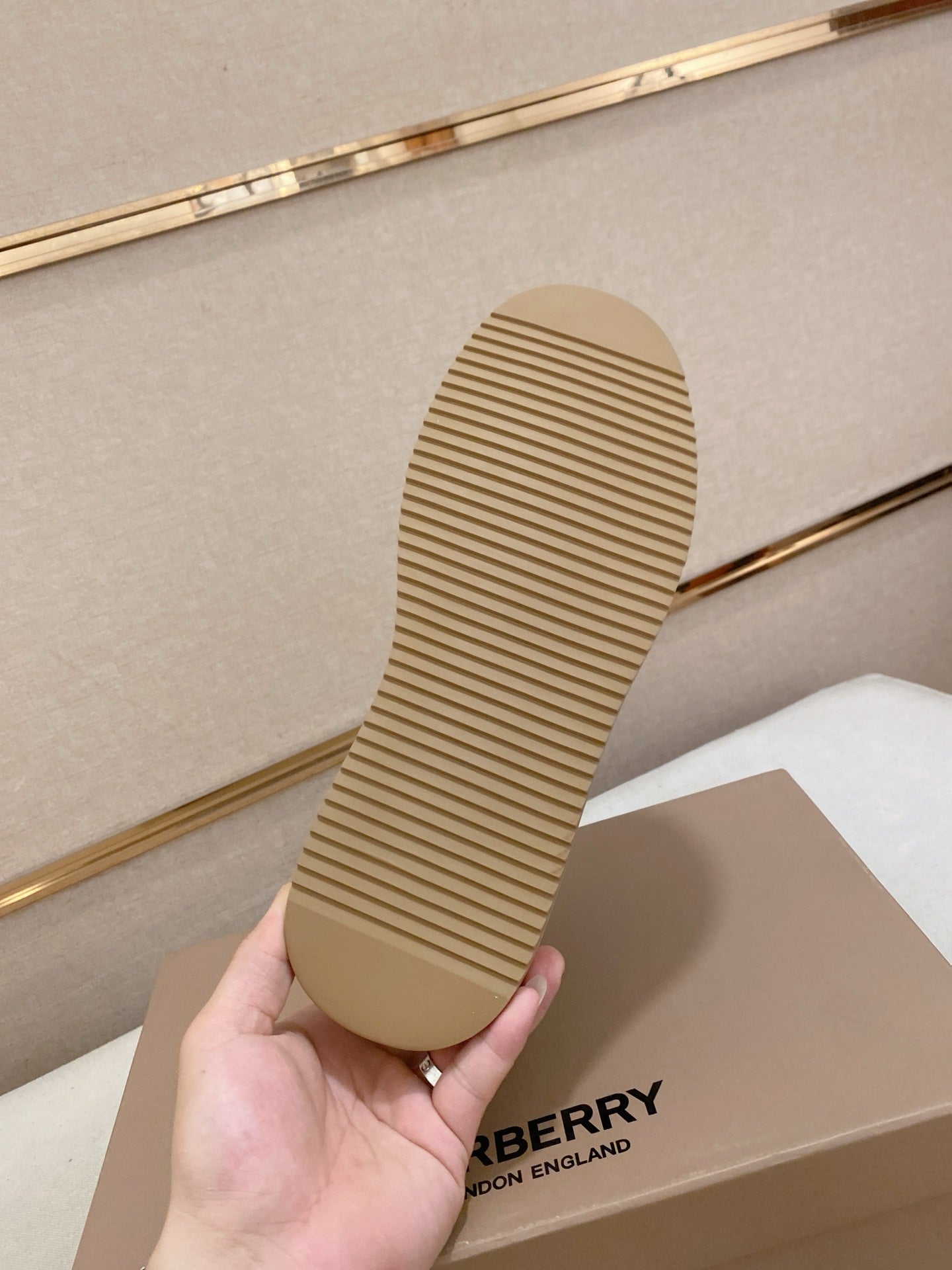 Shoe outsole with tan rubber tread held in hand