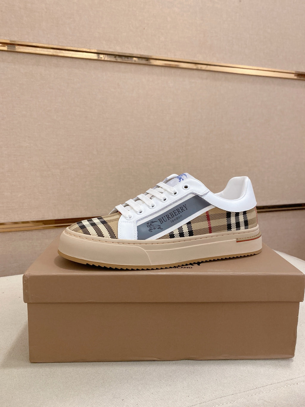 Low-top sneakers with white uppers, Burberry check side panel, and white laces