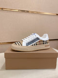 Low-top sneakers with white uppers, Burberry check side panel, and white laces