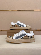 Pair of white low-top sneakers with plaid side panels and cream gum rubber soles