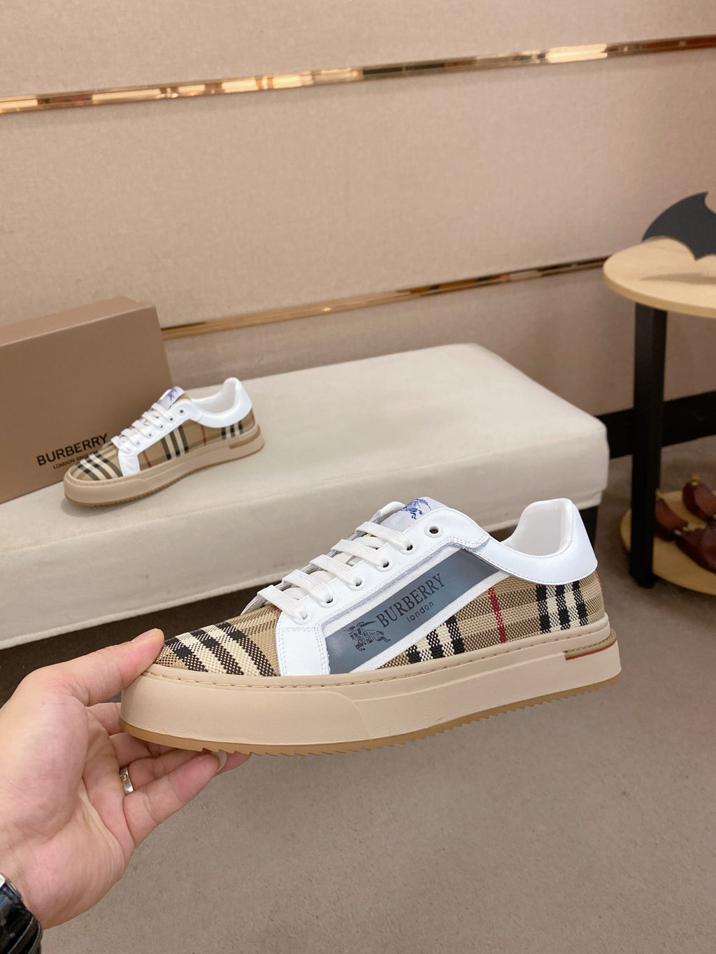 White and beige plaid low-top sneakers with blue logo on side and flat sole