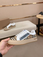 White and beige plaid low-top sneakers with blue logo on side and flat sole