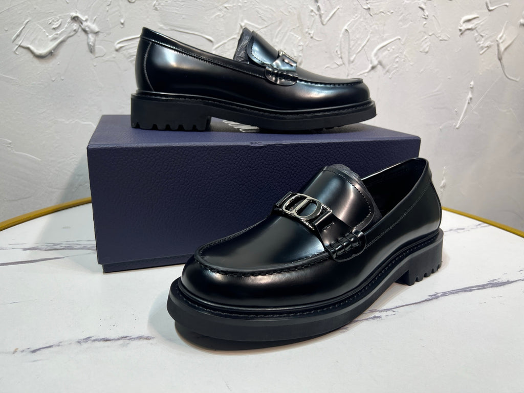 Black leather loafer with square buckle strap and layered platform sole, front angle