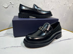 Black leather loafer with square buckle strap and layered platform sole, front angle