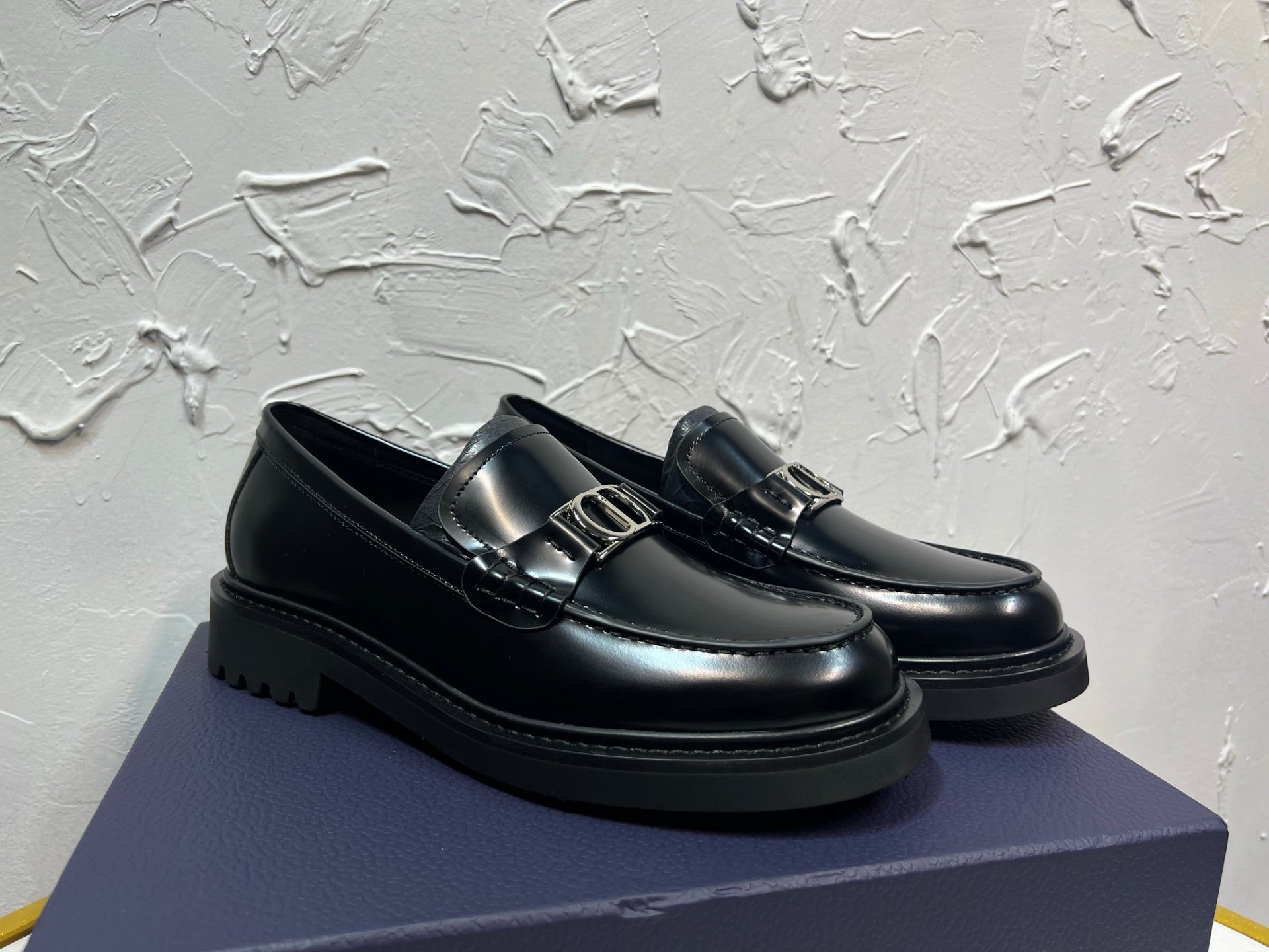 Black leather loafer with square metal buckle and stitched moc toe, platform sole