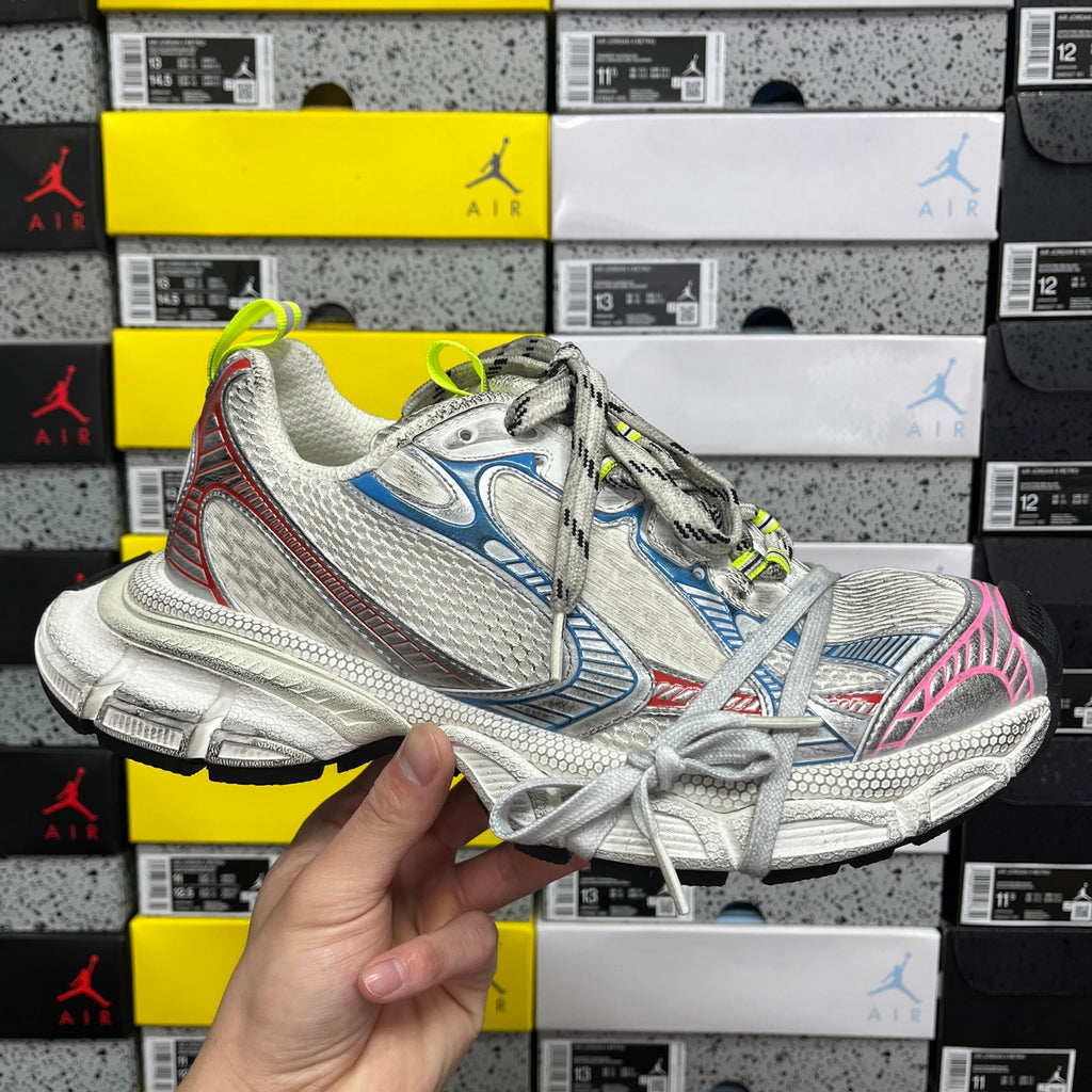 Chunky lace-up running shoe: white mesh, blue side panels, pink trim, neon green laces.