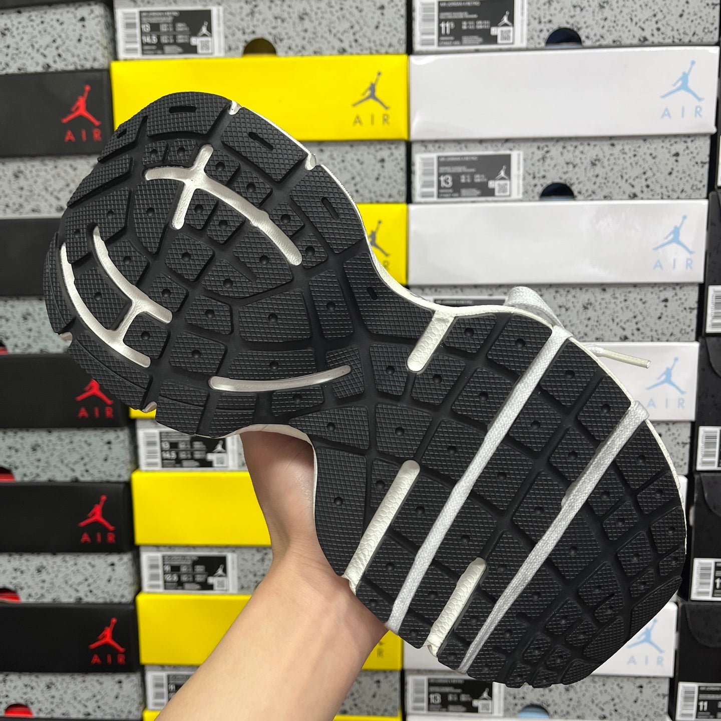 Rubber outsole for running shoe with dark tread and white sidewall stripes.