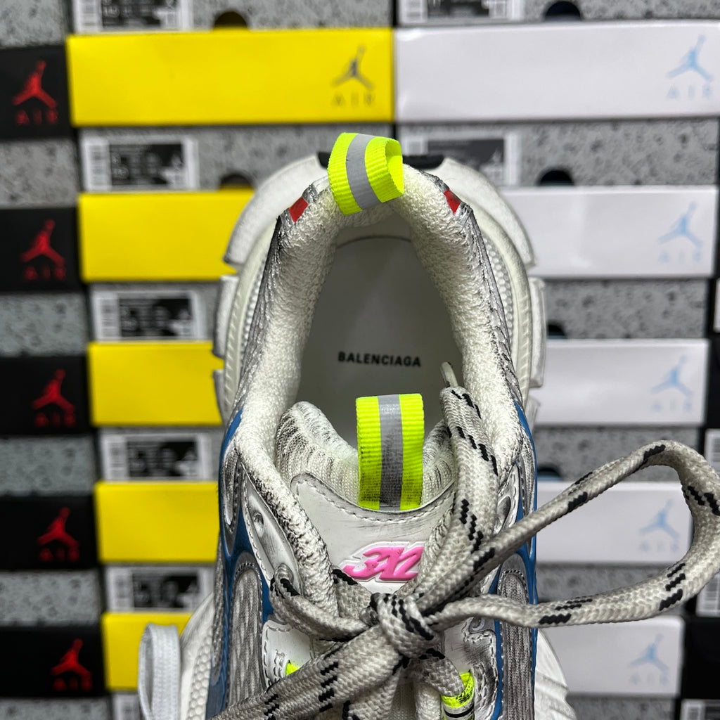 Back of lace-up shoe with Balenciaga insole text; neon green heel straps, white upper.