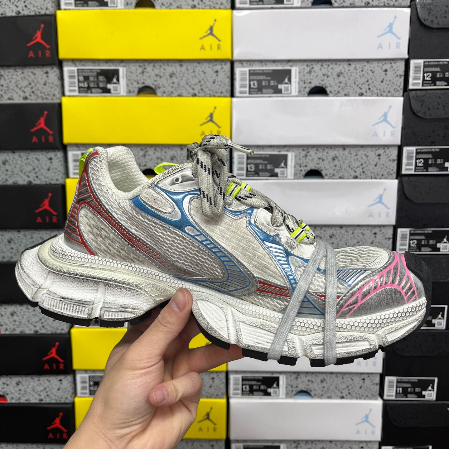 Lace-up running shoe with white mesh, blue panels, pink heel detail, neon green laces.