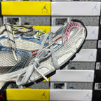Chunky running shoe sole and toe: white textured upper with blue stripe and pink edging.