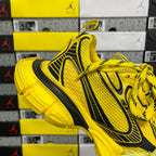 Yellow lace-up sneakers with black vertical side stripe and thick rubber sole