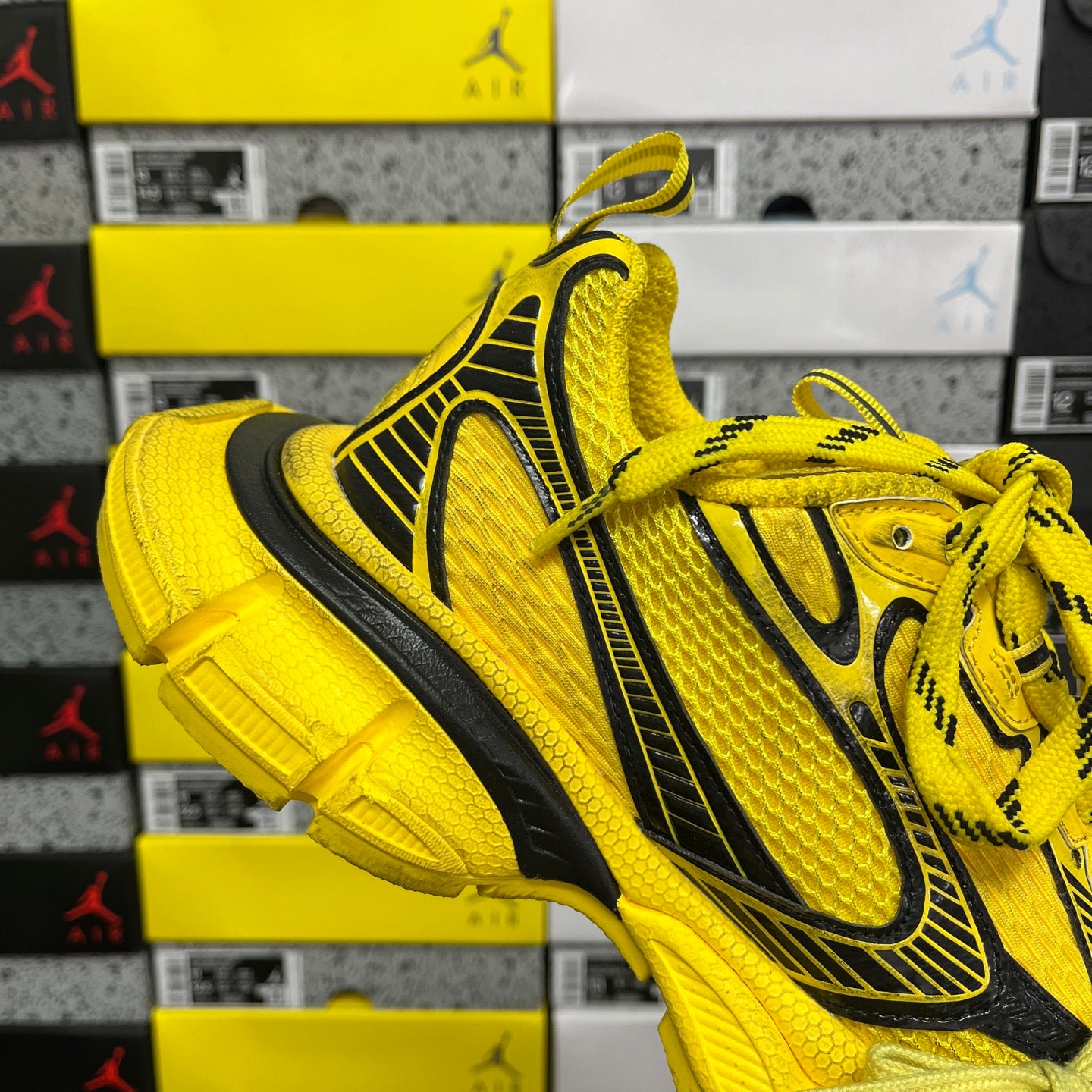 Yellow lace-up sneakers with black vertical side stripe and thick rubber sole
