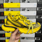 Yellow lace-up sneakers with black accents and chunky sole, shown side view