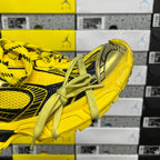 Yellow sneakers with black side stripe, metallic heel cap, lace-up design
